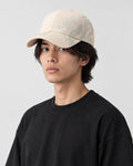 Man wearing the beige dragon print cap with a black tee, three-quarter view