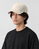 Man wearing the beige dragon print cap with a black tee, three-quarter view