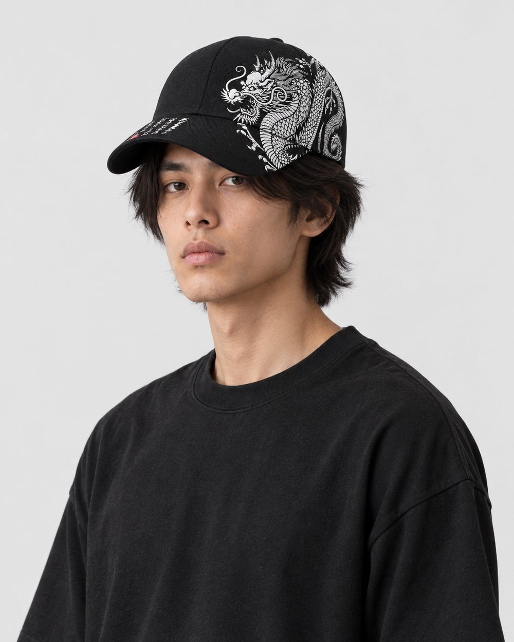 Model wearing the black dragon embroidered cap, side profile