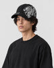 Model wearing the black dragon embroidered cap, side profile