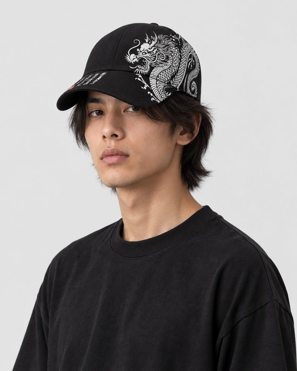 Model wearing the black dragon embroidered cap, three-quarter view