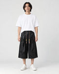 Model wearing the black dragon jacquard cropped wide-leg pants with a white tee and white sneakers, front view