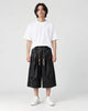 Model wearing the black dragon jacquard cropped wide-leg pants with a white tee and white sneakers, front view