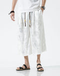 White dragon jacquard wide-leg pants with silver-gray dragons and a beaded, tasseled drawcord, worn with a white tee