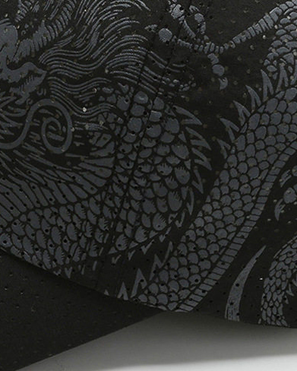 Close-up of the gray dragon print on the black cap