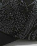 Close-up of the gray dragon print on the black cap
