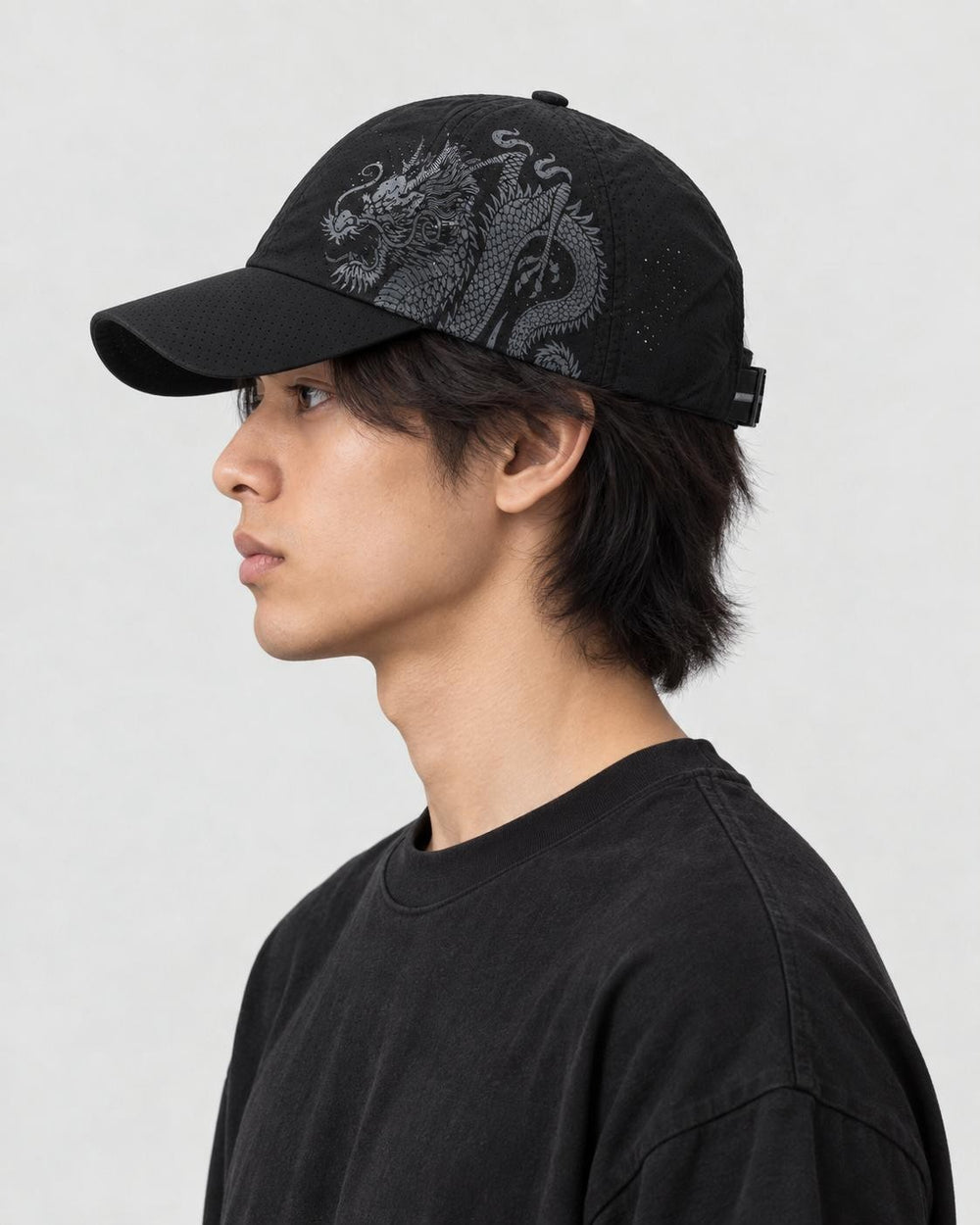 Model wearing the black dragon print cap, side view of the dragon