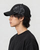 Model wearing the black dragon print cap, side view of the dragon