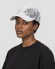Model wearing the white dragon print cap, three-quarter view
