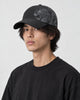 Model wearing the black dragon print cap, three-quarter view