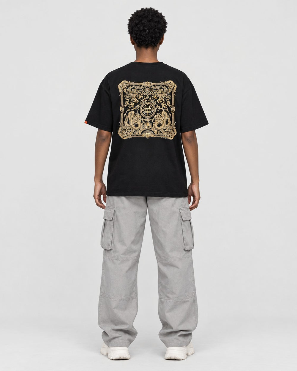 Model wearing the black dragon seal T-shirt, back view of the gold seal panel