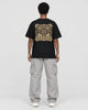 Model wearing the black dragon seal T-shirt, back view of the gold seal panel