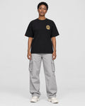 Model wearing the black dragon seal T-shirt with grey cargo pants, front view