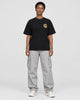 Model wearing the black dragon seal T-shirt with grey cargo pants, front view