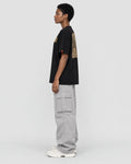 Model wearing the black dragon seal T-shirt with grey cargo pants, side view