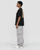 Model wearing the black dragon seal T-shirt with grey cargo pants, side view