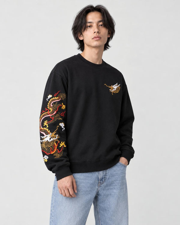 Model wearing the black dragon sleeve sweatshirt with light-wash jeans, three-quarter view
