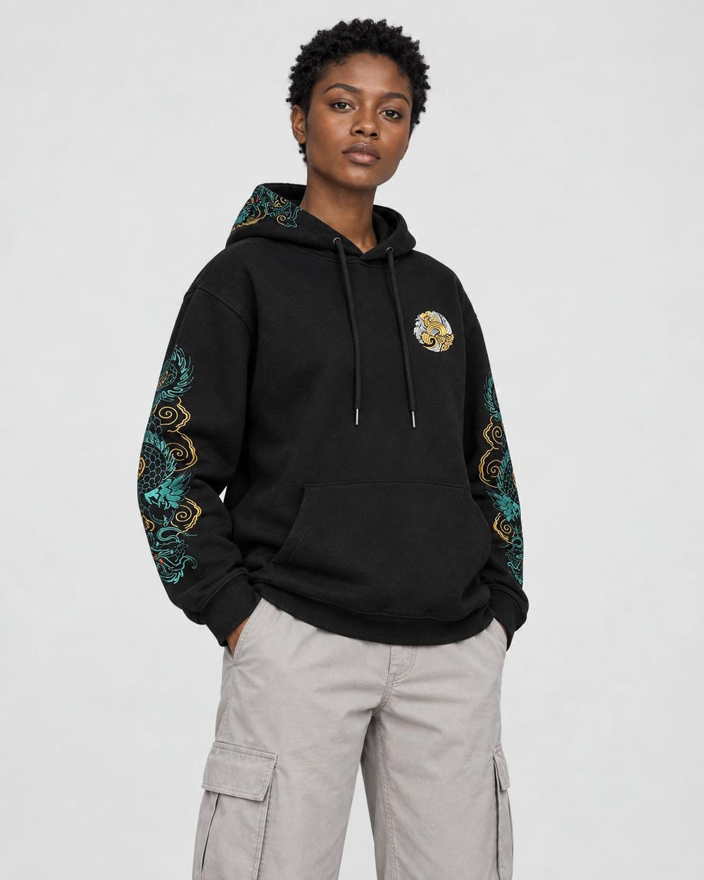 Model wearing the dragon sleeve hoodie with stone cargo trousers, three-quarter view