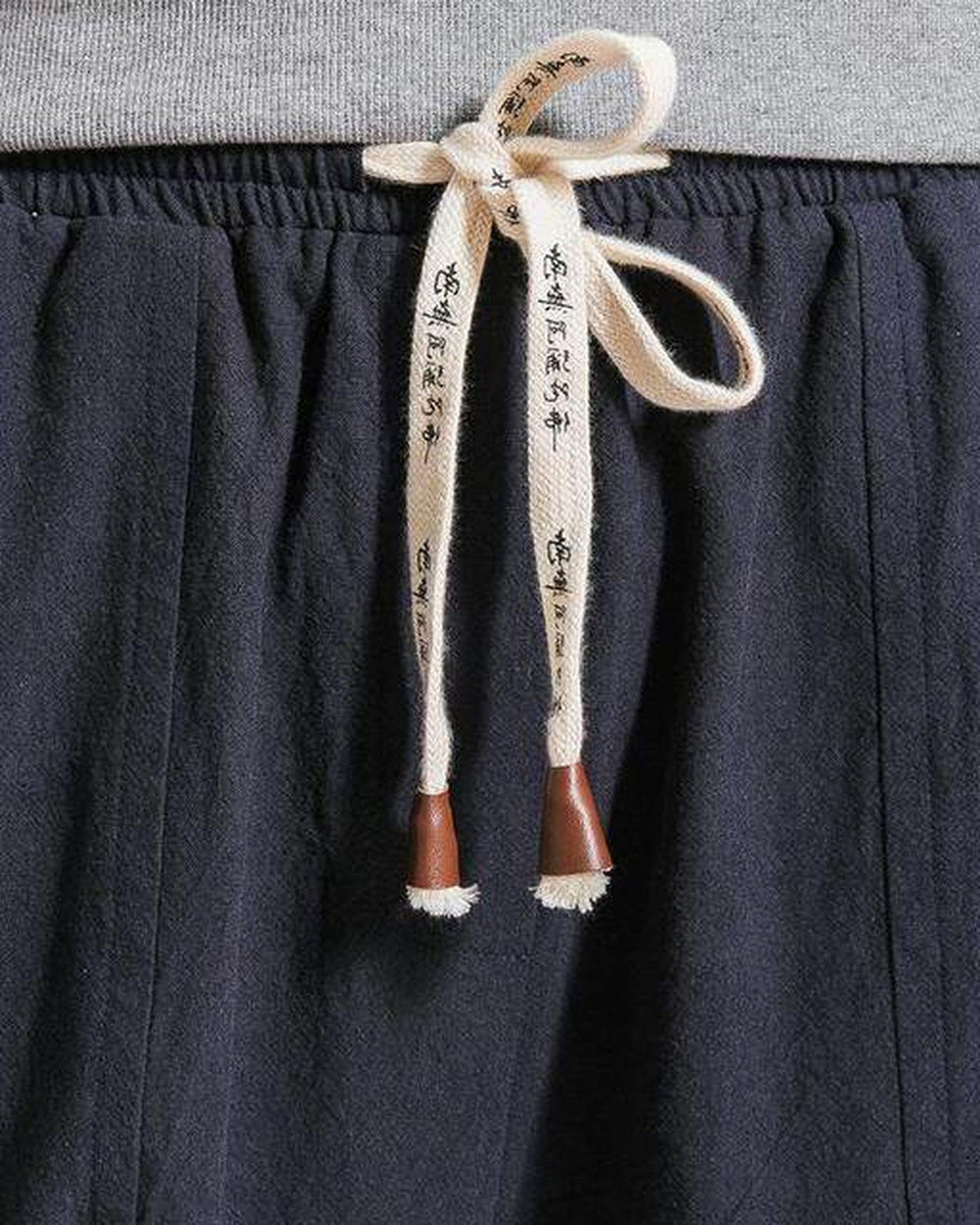 Close-up of the cream drawstring printed with black characters