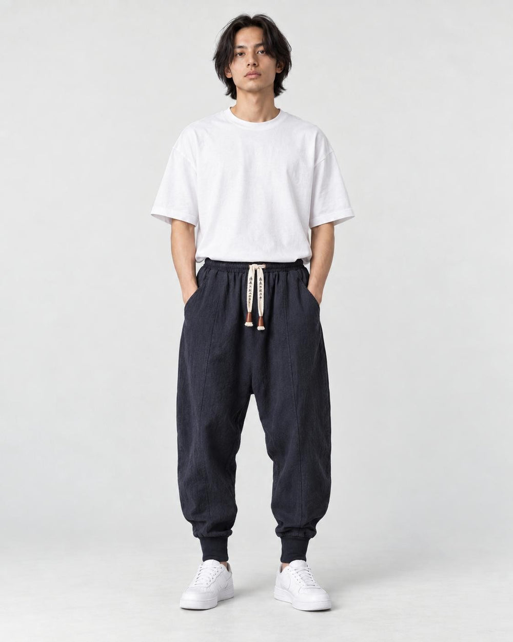 Model wearing the navy drop-crotch harem pants, front view