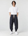 Model wearing the navy drop-crotch harem pants, front view