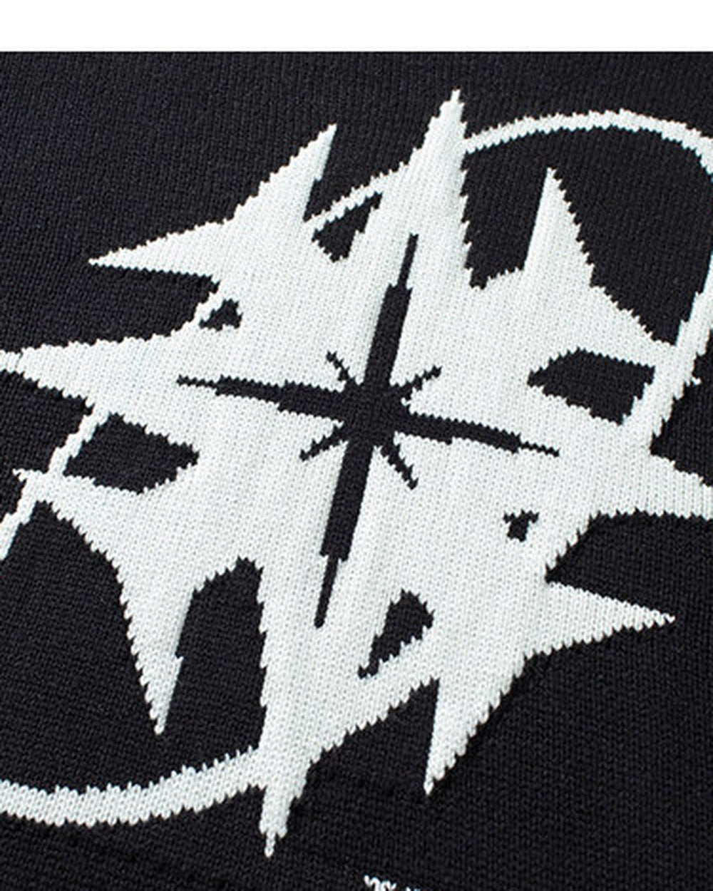 Close-up of the star and ring knitted into the black sweater