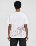 Model wearing the white butterfly embroidered T-shirt with black jeans, back view
