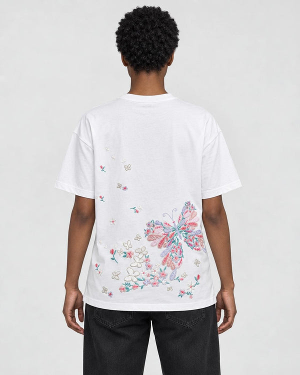 Model wearing the white butterfly embroidered T-shirt with black jeans, back view