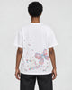 Model wearing the white butterfly embroidered T-shirt with black jeans, back view