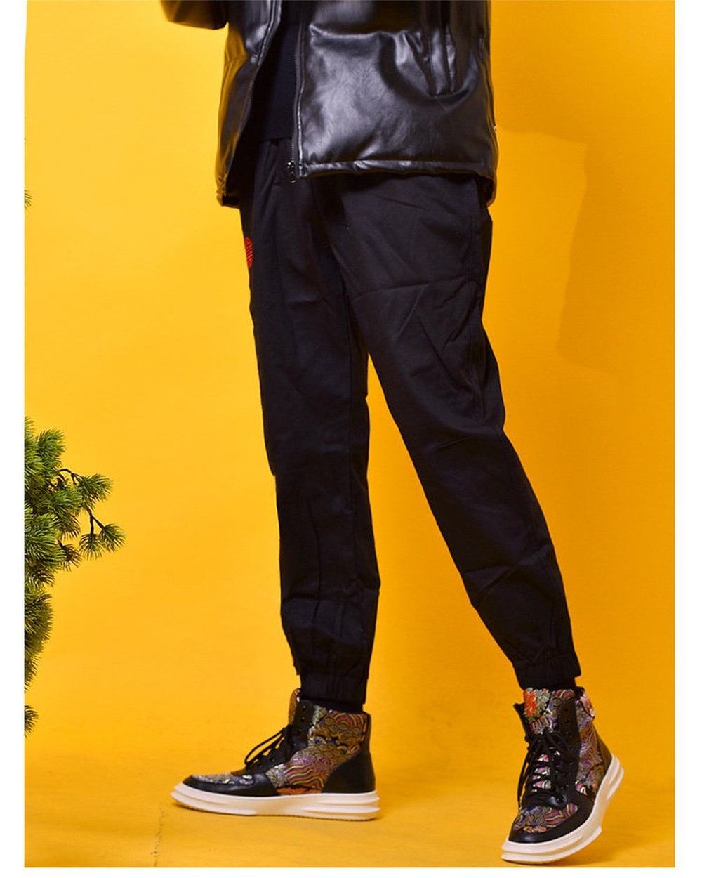 Black joggers worn with ankle boots, showing a plain leg, the red seal at the hip and the elastic gathered cuffs