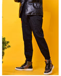 Black joggers worn with ankle boots, showing a plain leg, the red seal at the hip and the elastic gathered cuffs