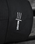 Close-up of the white three-line mark embroidered on the side of the hat