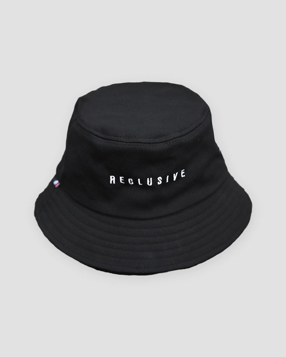 Black bucket hat with RECLUSIVE embroidered in white across the front