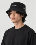 Model wearing the RECLUSIVE bucket hat, three-quarter view