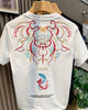 Back of the white T-shirt with a red, gold and teal embroidered mask, the word MIRACLE and a teal and a coral koi