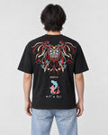 Man seen from behind in the black T-shirt with a large embroidered lion-dog mask, the word MIRACLE and two koi on the back