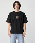 Man in the black T-shirt with a small vertical embroidered MIRACLE emblem on the chest, jeans and white sneakers