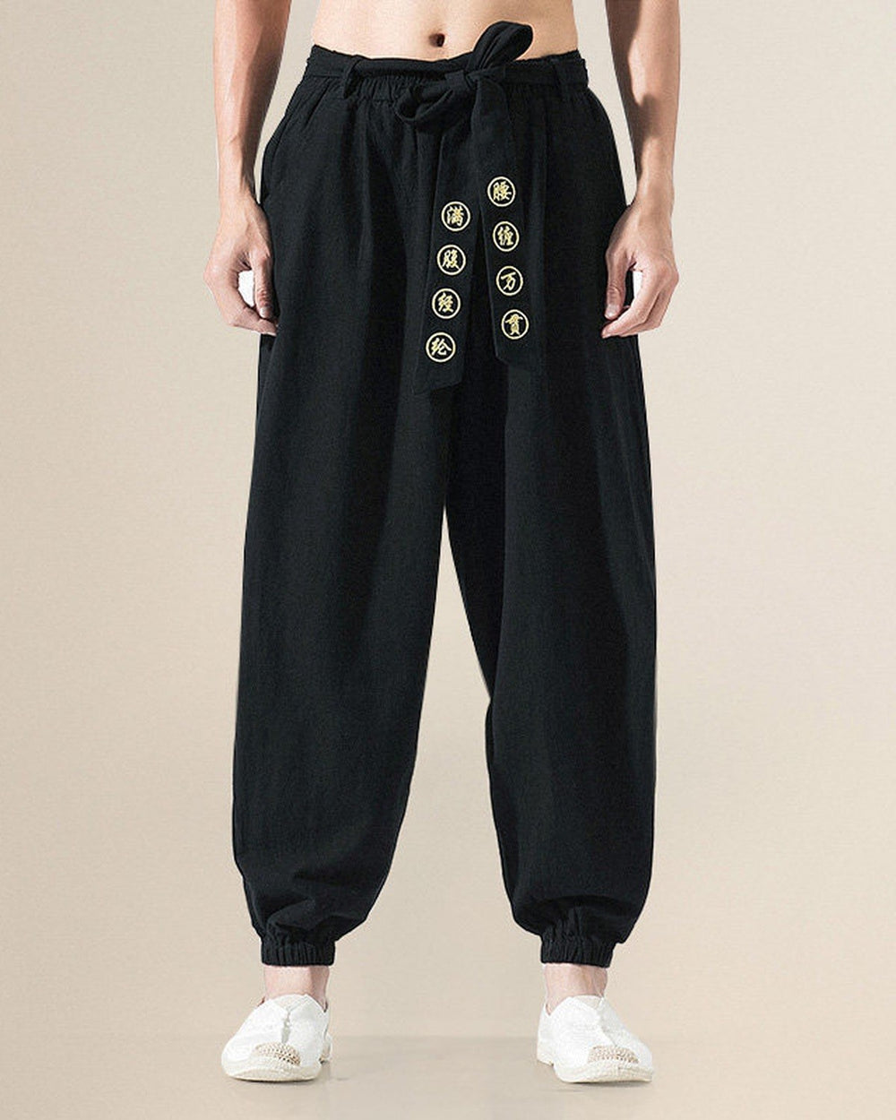 Black harem pants with the gold medallion sash hanging down the front