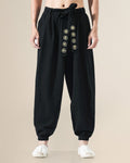 Black harem pants with the gold medallion sash hanging down the front