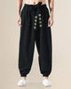 Black harem pants with the gold medallion sash hanging down the front