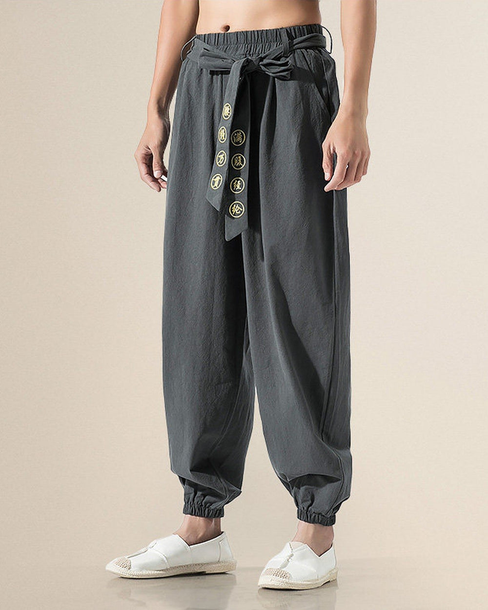 Dark gray harem pants with the embroidered sash tied in a bow, front view