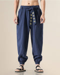 Navy harem pants with the embroidered sash tied at the waist, front view