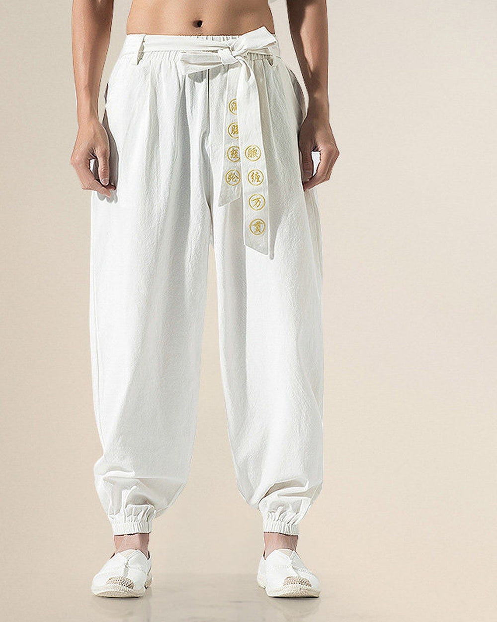 White harem pants with a cream sash embroidered with gold medallions, front view