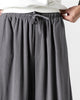Close-up of the wide elastic waistband and the flat drawcord bow on the dark gray pants