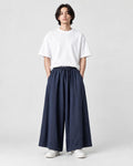 Model wearing the navy extra-wide linen-cotton skirt pants with a white tee and white sneakers, front view