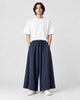 Model wearing the navy extra-wide linen-cotton skirt pants with a white tee and white sneakers, front view