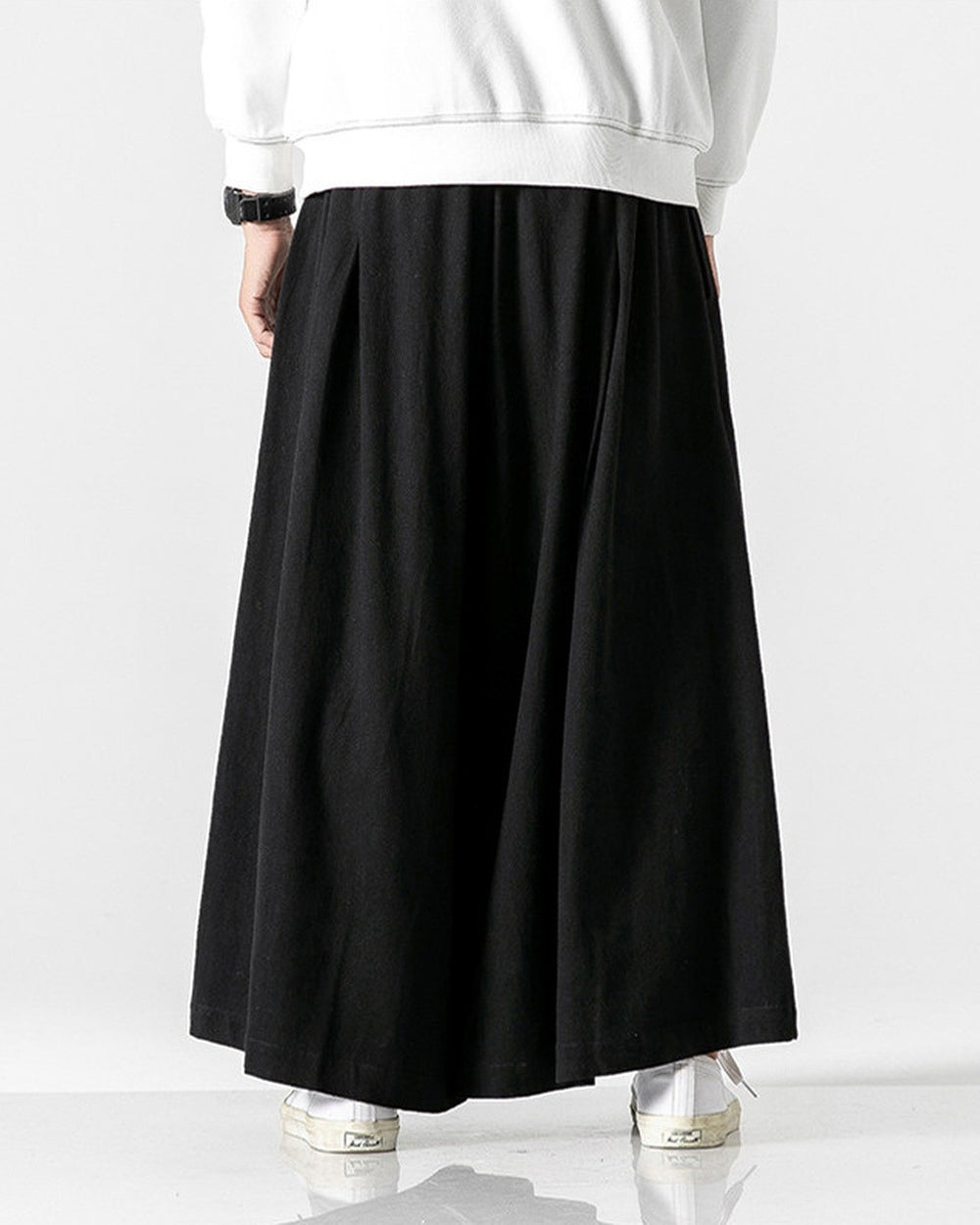 Black extra-wide linen-cotton skirt pants worn with a white sweatshirt and white sneakers