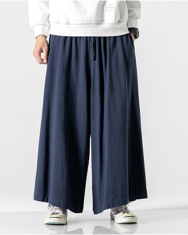 Navy extra-wide linen-cotton skirt pants worn with a white sweatshirt and white sneakers, front view