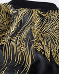 Close-up of the gold thread wings embroidered across the shoulders
