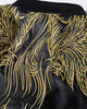 Close-up of the gold thread wings embroidered across the shoulders